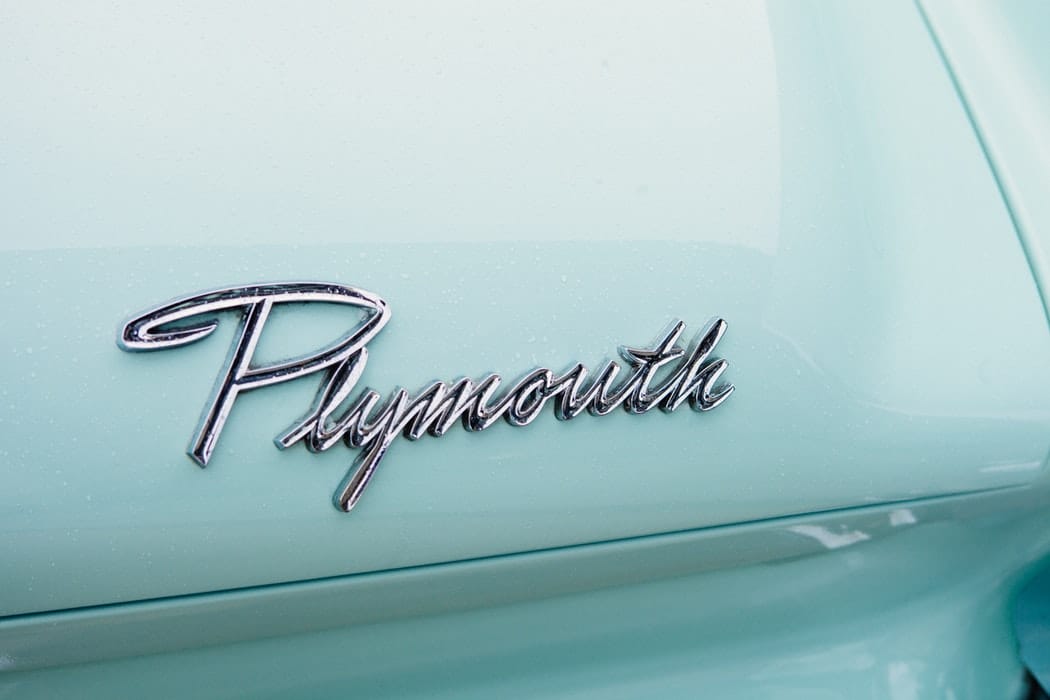 "Plymouth" written in fancy silver cursive on teal car