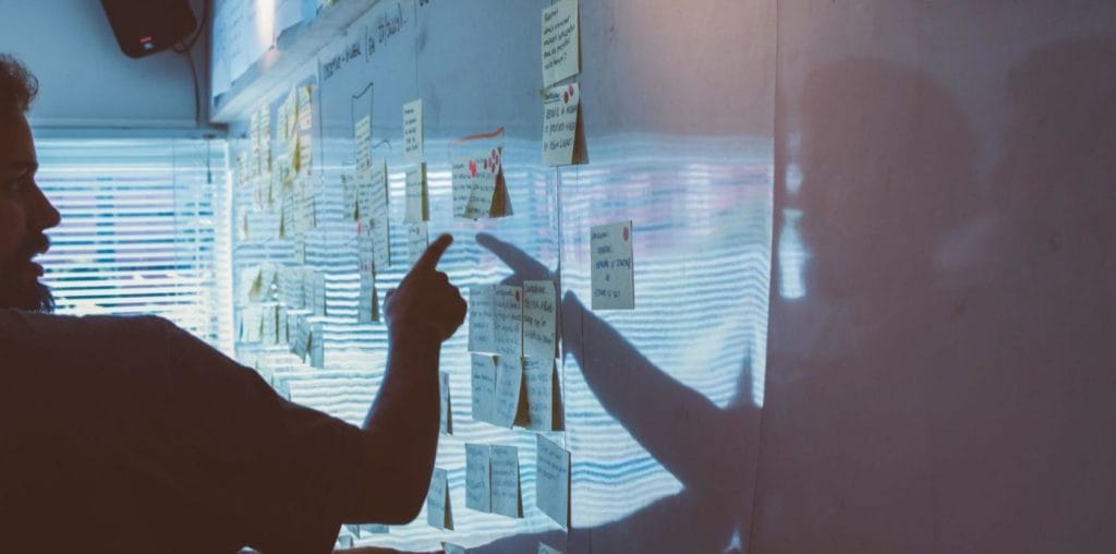 image3 Finger pointing to sticky note on white board